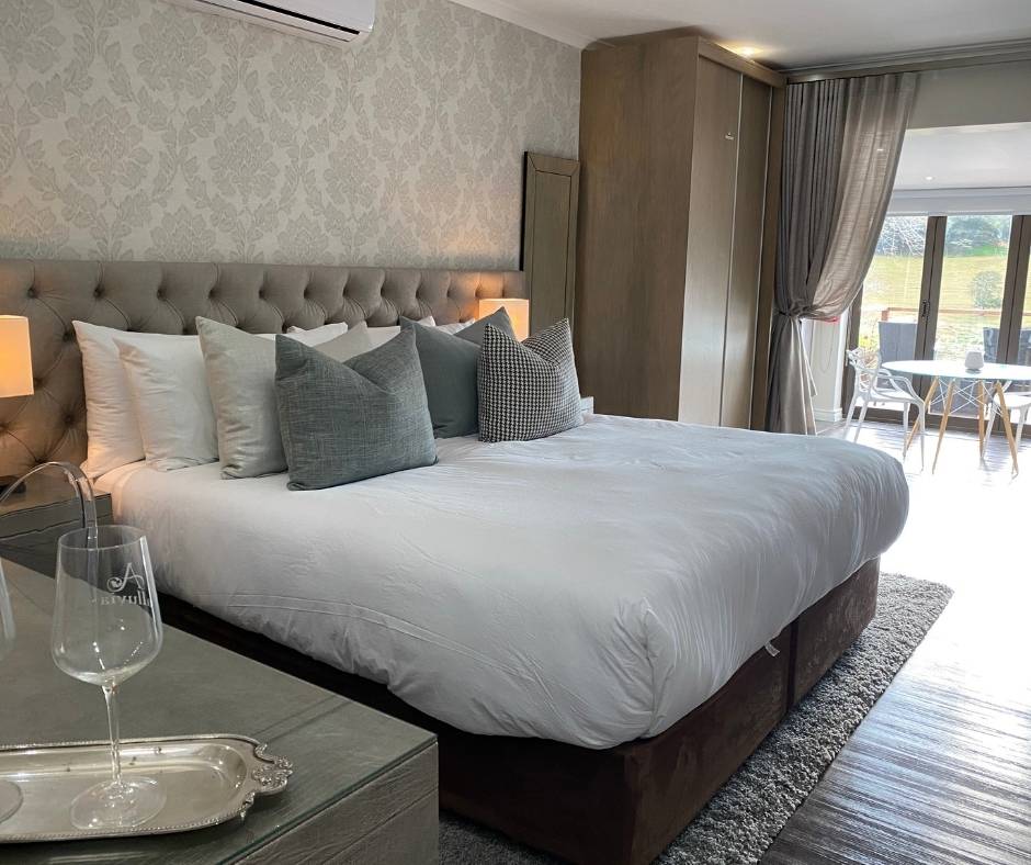 luxury suite bedroom with pale blue and white bed and a lounge area